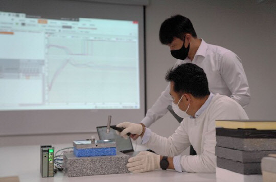 롯데건설 관계자가 층간완충재 실험 결과를 확인하고 있는 모습 <롯데건설 제공>